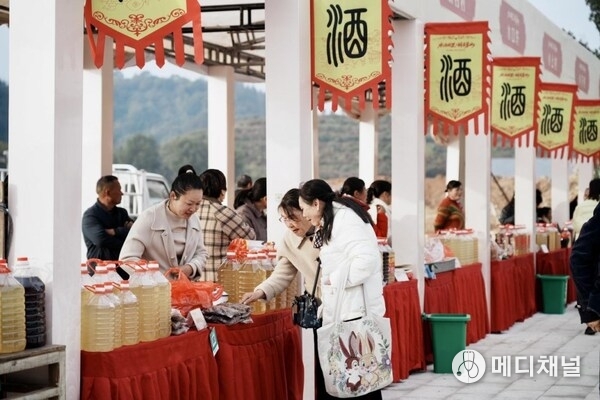 The photo shows that visitors are tasting local wine at the annual culture festival held in Mengshan Town in east China