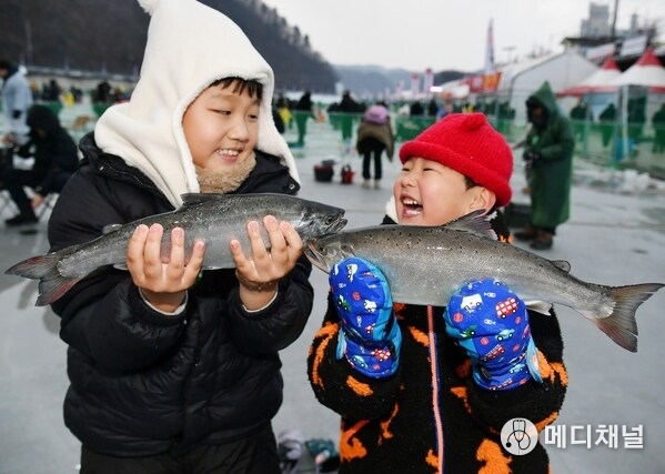 This photo provided by Hwacheon County on Jan. 10, 2026, shows children catching fish at the Hwacheon Sancheoneo Ice Festival in the remote mountain town in the northeastern province of Gangwon. (PHOTO NOT FOR SALE)